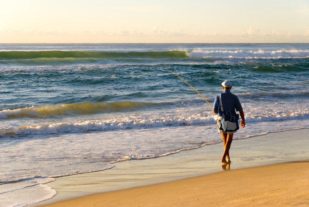 太阳升起时海边的渔民图片下载