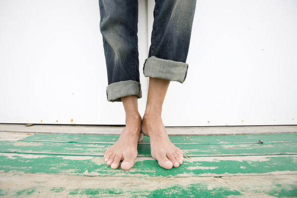 一个人站在海边小屋旁的脚图片下载