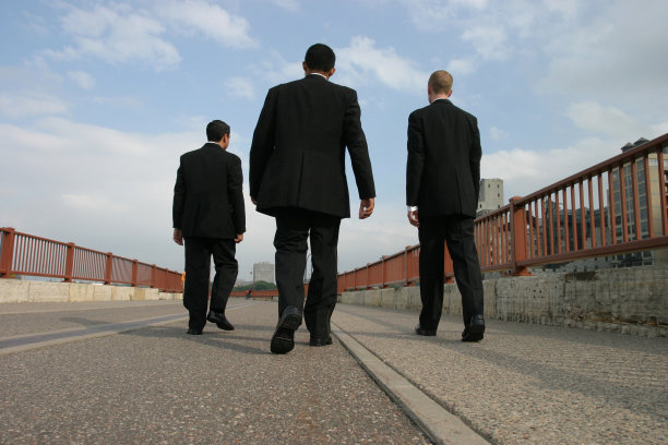 穿着黑色西装走路的商人图片下载