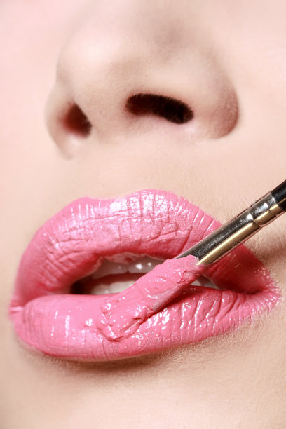 用化妆刷涂抹口红，特写图片下载