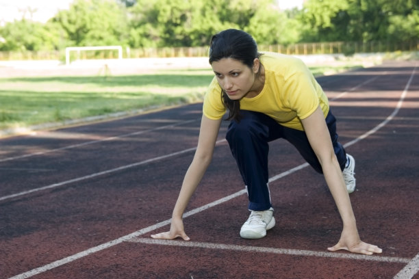 年轻女子准备在跑道上跑步图片下载