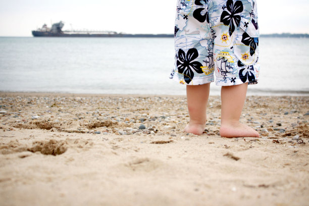 小男孩站在海滩上图片下载