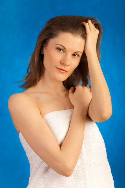 裹着毛巾的漂亮女孩。影棚拍摄。图片下载