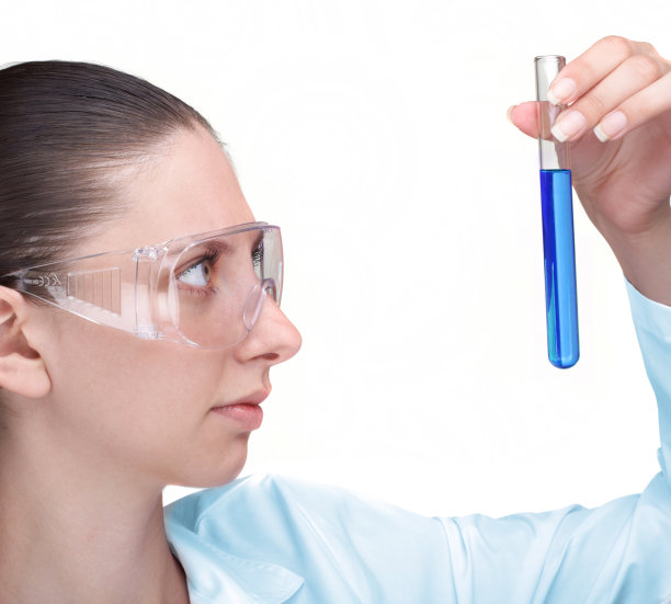 女科学家在试管中观察蓝色液体图片下载