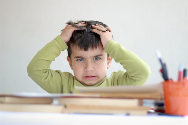 小男孩抓着头发，脸上带着厌烦的表情图片下载