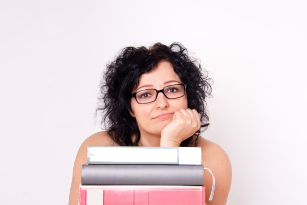 拿着书的年轻女子。图片下载