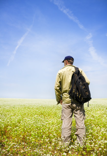 鲜花草地上的年轻人。图片下载