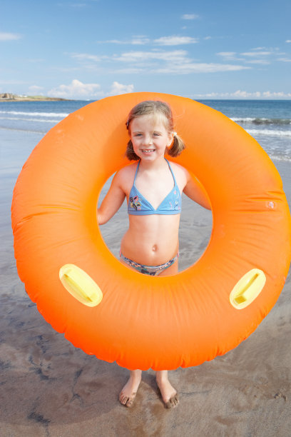 沙滩上的孩子戴着巨大的橡皮环图片下载
