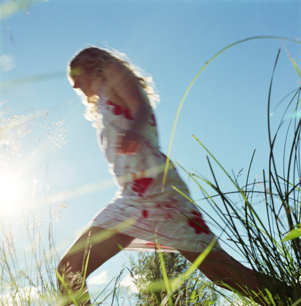 年轻的女人走在田野上图片下载