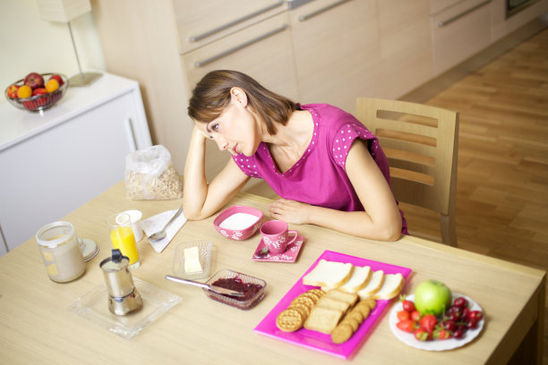 穿着睡衣在家吃早餐的疲惫女人图片下载