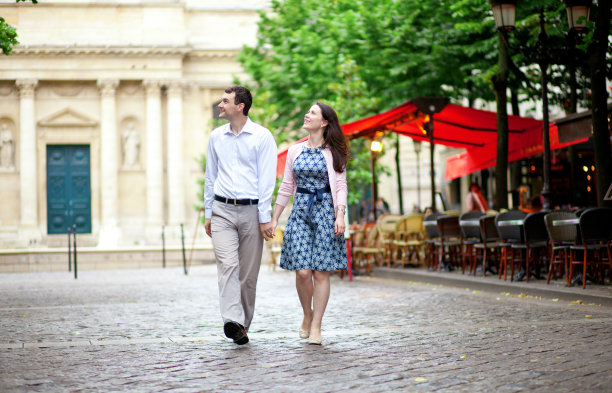 一对情侣在巴黎街头咖啡馆附近散步图片下载