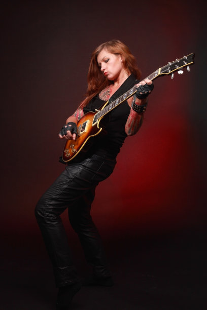 有很多纹身的迷人女孩在弹电吉他图片下载