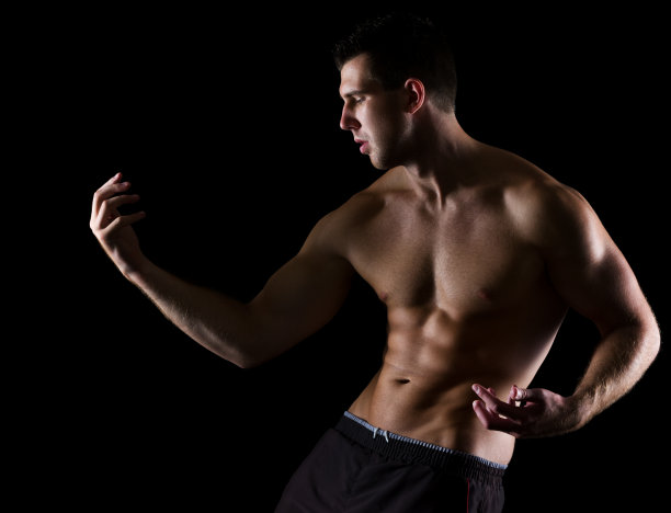 强壮的肌肉男子优雅地摆姿势在黑色图片下载