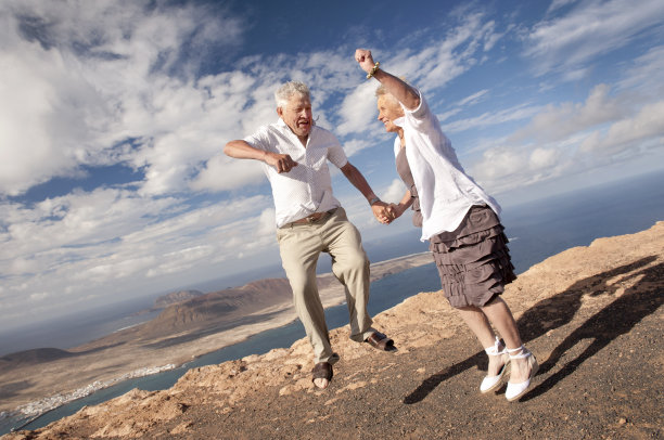 一对健康的老夫妇在空中跳得很高图片下载