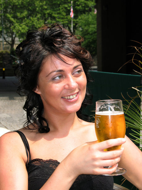 快乐女孩在阳光明媚的日子喝啤酒图片下载