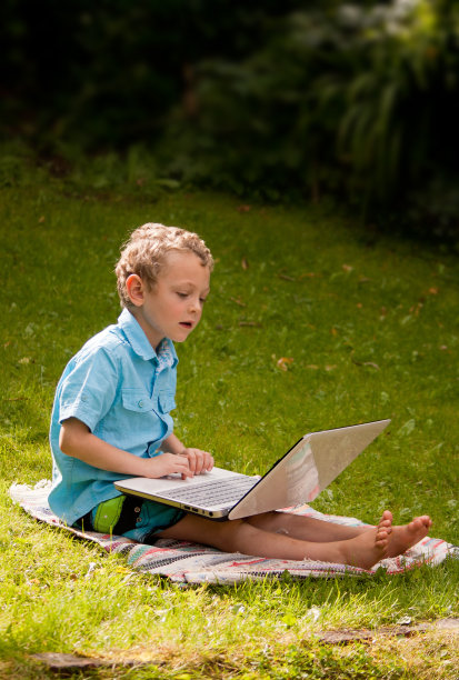 一个小男孩在用笔记本电脑图片下载