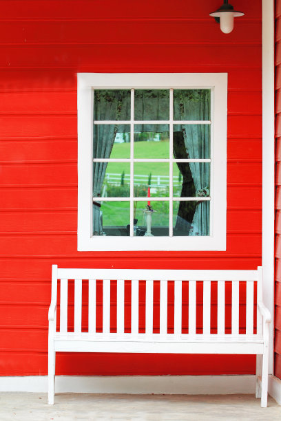 白色的椅子靠在红色的墙上图片下载