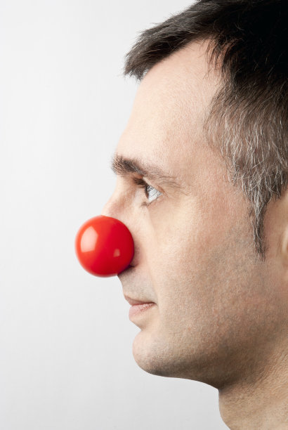 一个戴着小丑鼻子的严肃男人的侧面图片下载