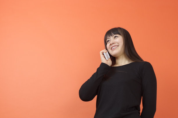 亚洲妇女与手机交谈图片下载