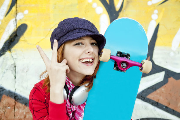 一个快乐的年轻女孩与滑板的特写肖像图片下载