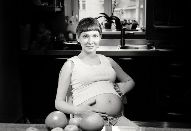 孕妇与水果在厨房的单色肖像图片下载