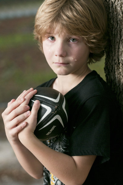 男孩拿着一个足球哭图片下载