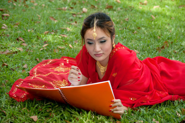 一个漂亮的亚洲女人在看书。图片下载