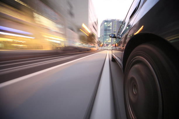 在夕阳下的城市里开车。图片下载