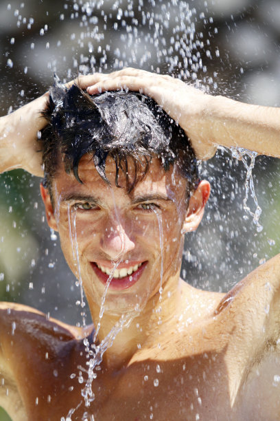 一个美丽的少年在淋浴微笑的肖像图片下载