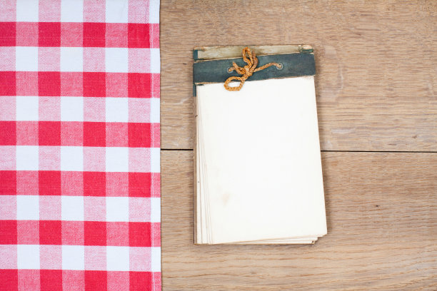 桌布以纺织品质地，旧食谱为背景的木桌图片下载
