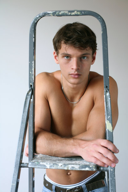 年轻的肌肉发达的人与一个活梯图片下载