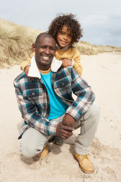 父亲和儿子在冬天的海滩图片下载