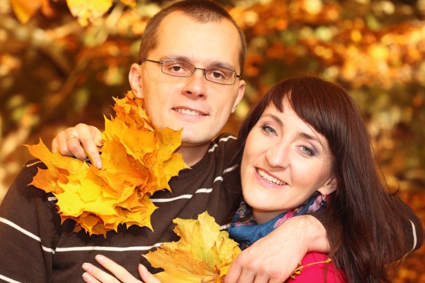 男人和女人手里拿着秋天的树叶图片下载