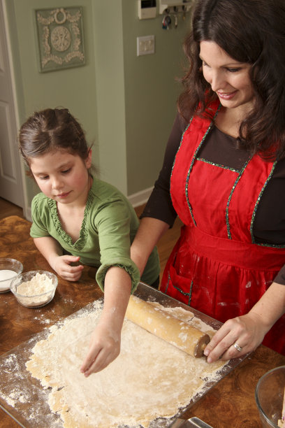 母亲和女儿在擀饼干面团图片下载