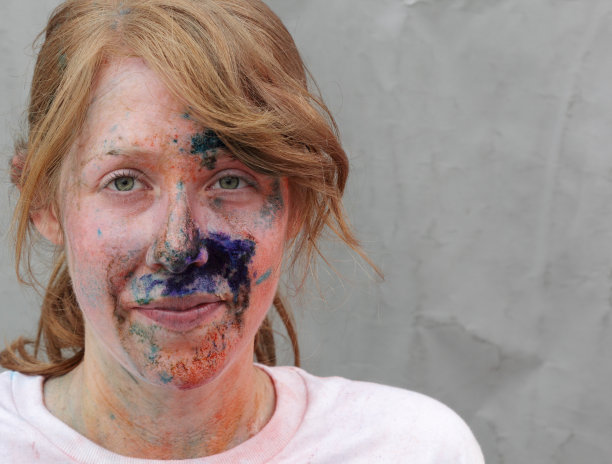 微笑的女性与彩色的脸看着相机图片下载