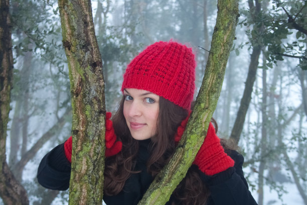 美丽的年轻女子在一个冬天的森林背景图片下载