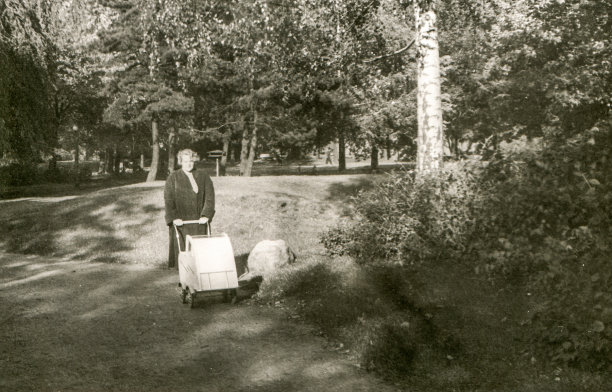 一名妇女推着婴儿车走路的复古照片图片下载