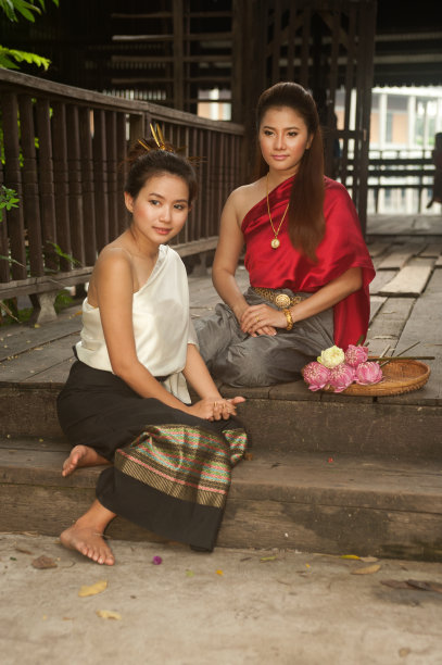 双胞胎漂亮女人坐在摆姿势。图片下载