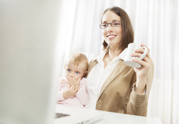 母亲在家工作时带着孩子工作。图片下载