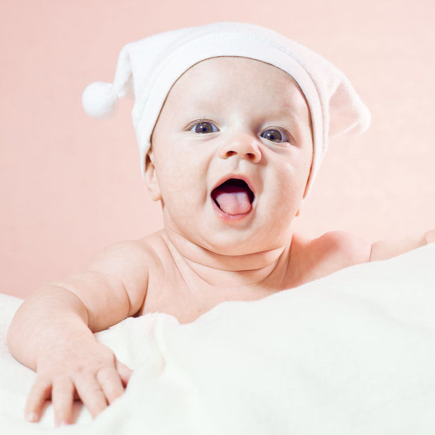 可爱的笑着的小婴儿戴着白色的帽子图片下载