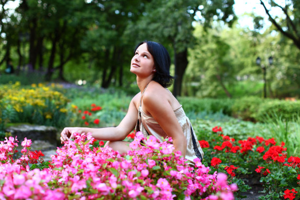 美丽的女孩在公园里，带着五颜六色的花图片下载