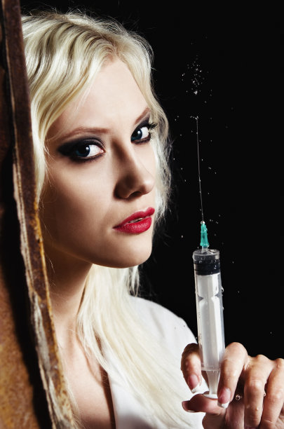 性感年轻护士手里拿着注射器。特写镜头图片下载