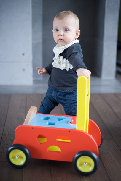 小女孩站在玩具车上图片下载