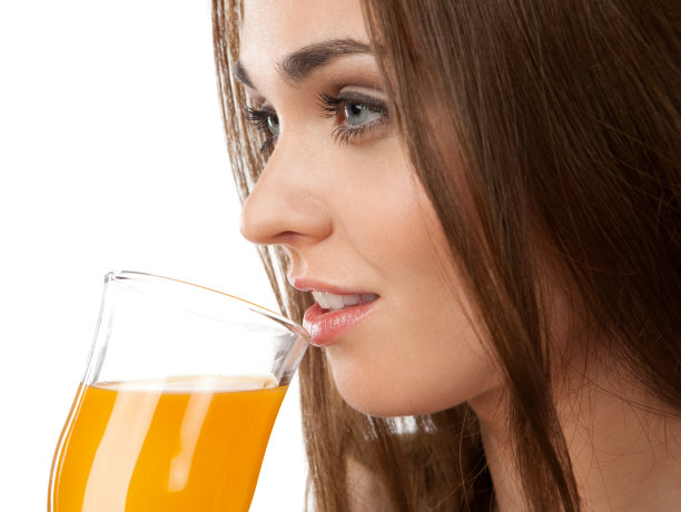 白色背景下，年轻女子喝着果汁图片下载
