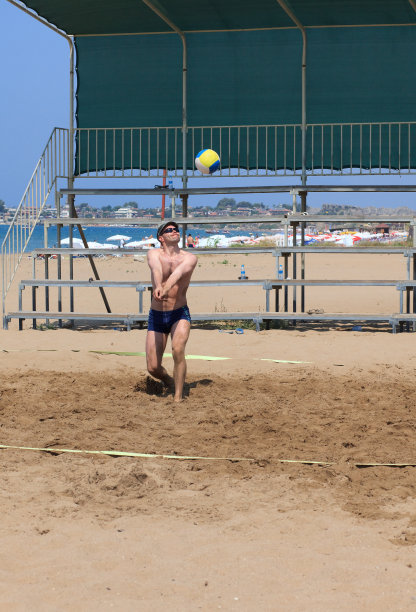 男人在沙滩上打排球图片下载