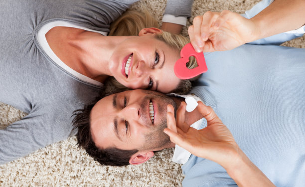 一对幸福浪漫的情侣躺在地毯上图片下载