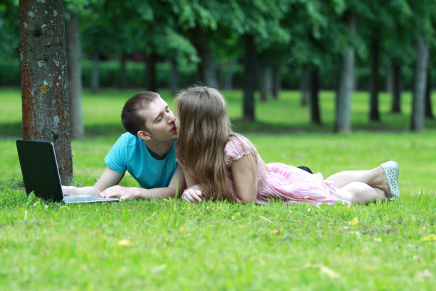 一对夫妇在公园里带着笔记本电脑图片下载