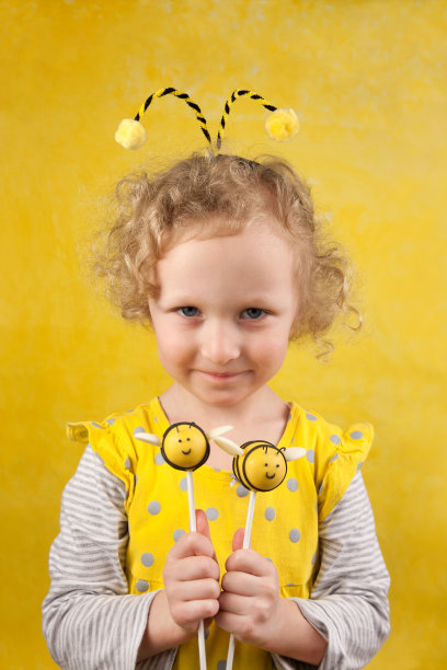 有蜜蜂蛋糕棒棒糖的女孩图片下载