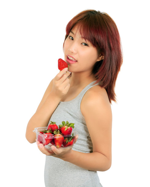 孤立的年轻亚洲女人吃草莓图片下载