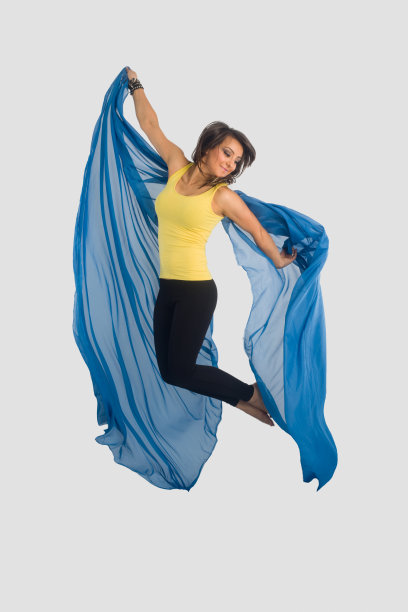 快乐的女人用蓝色透明的布跳着——孤立图片下载